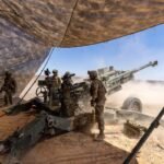 Les parachutistes de l'armée américaine tirent un obusier de 155 mm depuis un obusier M777 lors d'un…