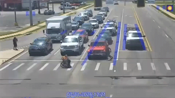 Le bon Samaritain en costume de Spider-Man aide un homme en fauteuil roulant à traverser une intersection très fréquentée dans un moment viral
