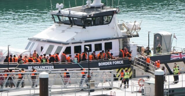 Des manifestants vêtus de noir en cagoules défilent à Douvres contre la crise des migrants dans la Manche