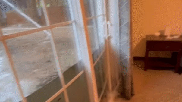 Une vidéo dramatique capture les eaux de crue déferlant à travers les portes vitrées de la maison des étudiants